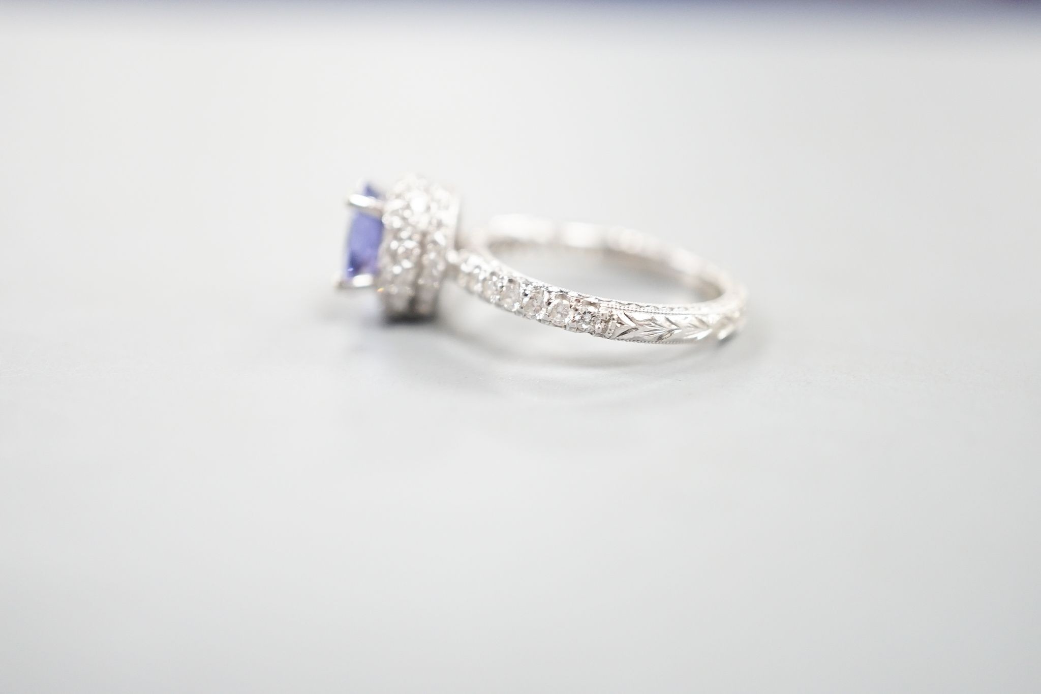 Two modern 18k white metal, tanzanite and diamond set dress rings, size J, gross 8.3 grams and a modern 9ct white gold and gem set ring, gross 2 grams.